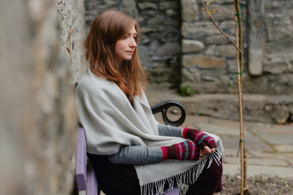 Woman wearing a grey scarf and knitted mitts which was made using a Fair Isle Knitting Patterns